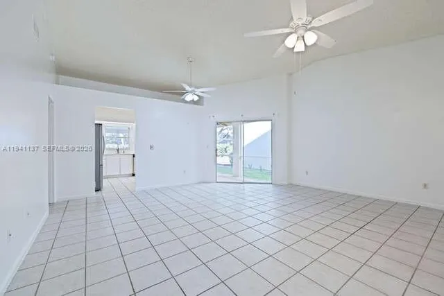an empty room with fan and windows