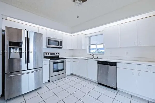 an empty room with a window and a fan