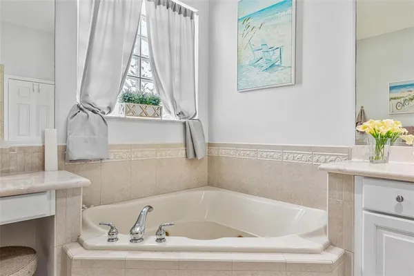 a white bath tub sitting in a bathroom next to a window