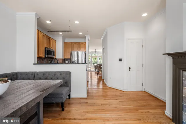 a living room with stainless steel appliances kitchen island granite countertop furniture and a wooden floor