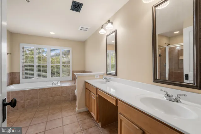a bathroom with a tub sink and mirror