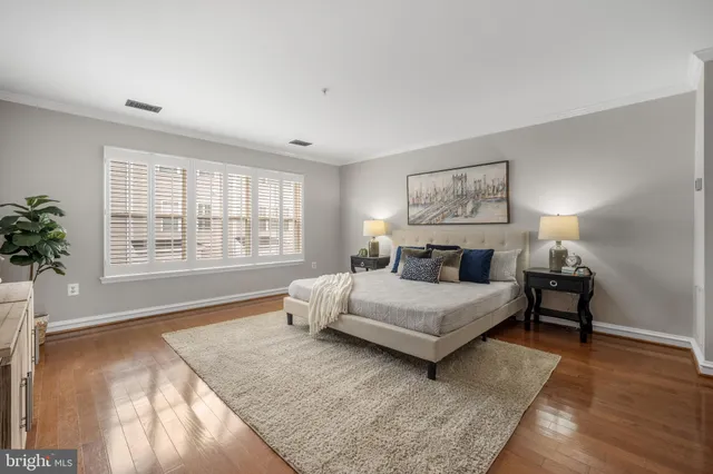 a spacious bedroom with a bed and wooden floor