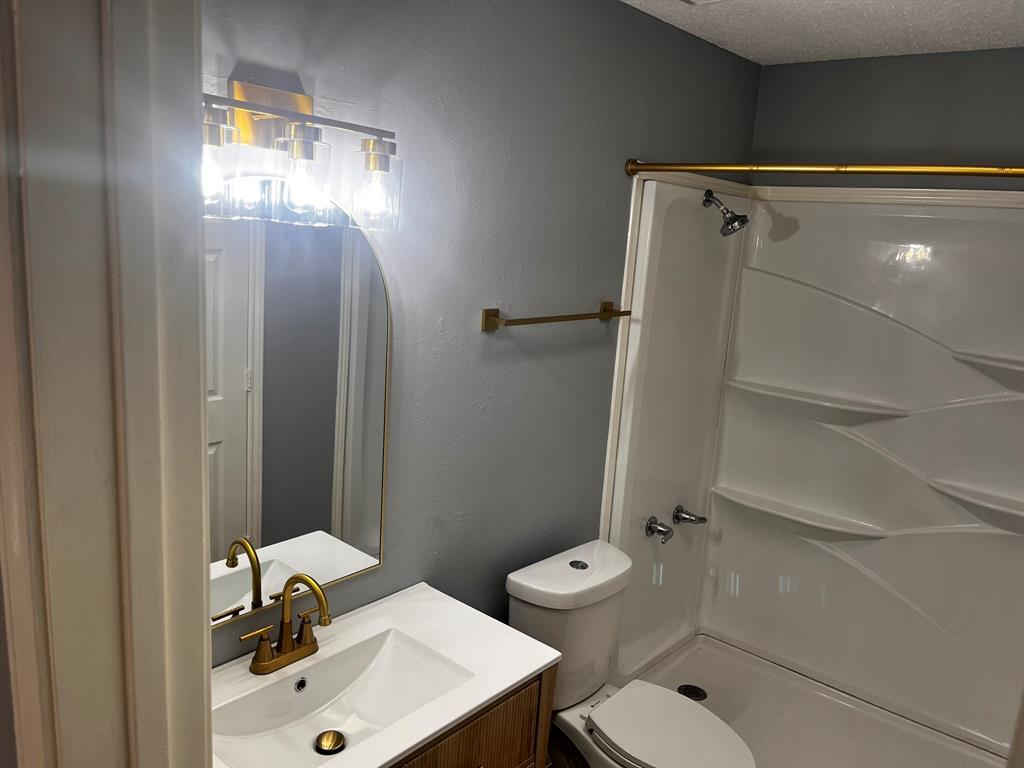 1007 Mack Place Denton, TX 76209 - Photo 23 of 37 Bathroom featuring vanity, a stall shower, a textured wall, and a textured ceiling