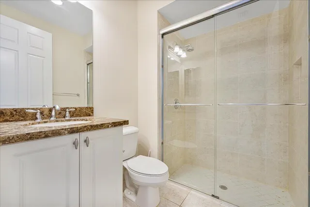 a bathroom with a granite countertop sink toilet and shower