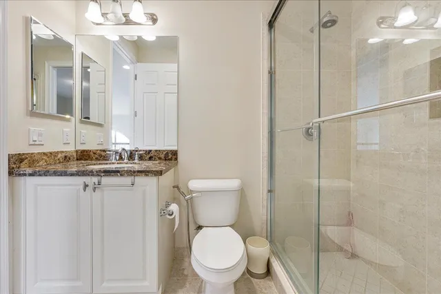 a bathroom with a granite countertop sink toilet and shower