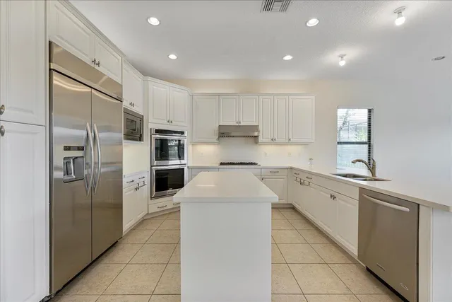 a kitchen with stainless steel appliances a refrigerator sink and cabinets