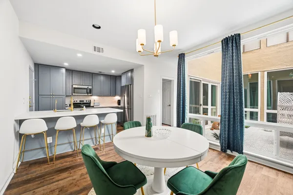 a view of a dining room with furniture a chandelier and wooden floor