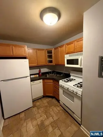 a kitchen with a refrigerator a stove top oven a sink and dishwasher