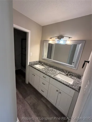 a bathroom with a granite countertop sink and a mirror