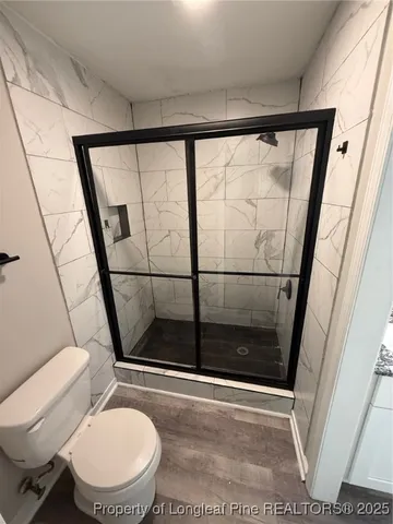 a bathroom with a toilet and a shower