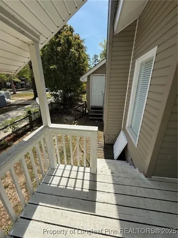 a view of balcony with wooden floor and potted plants