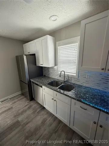 a kitchen with stainless steel appliances granite countertop a sink a stove a refrigerator and island