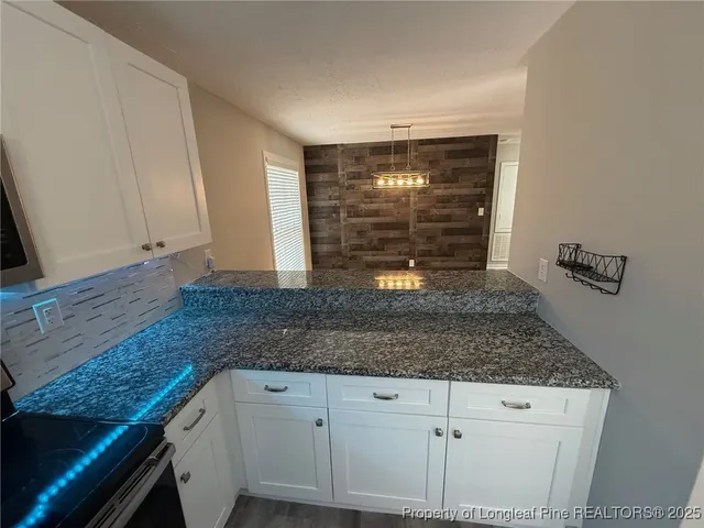 a kitchen with granite countertop a sink and a counter top space