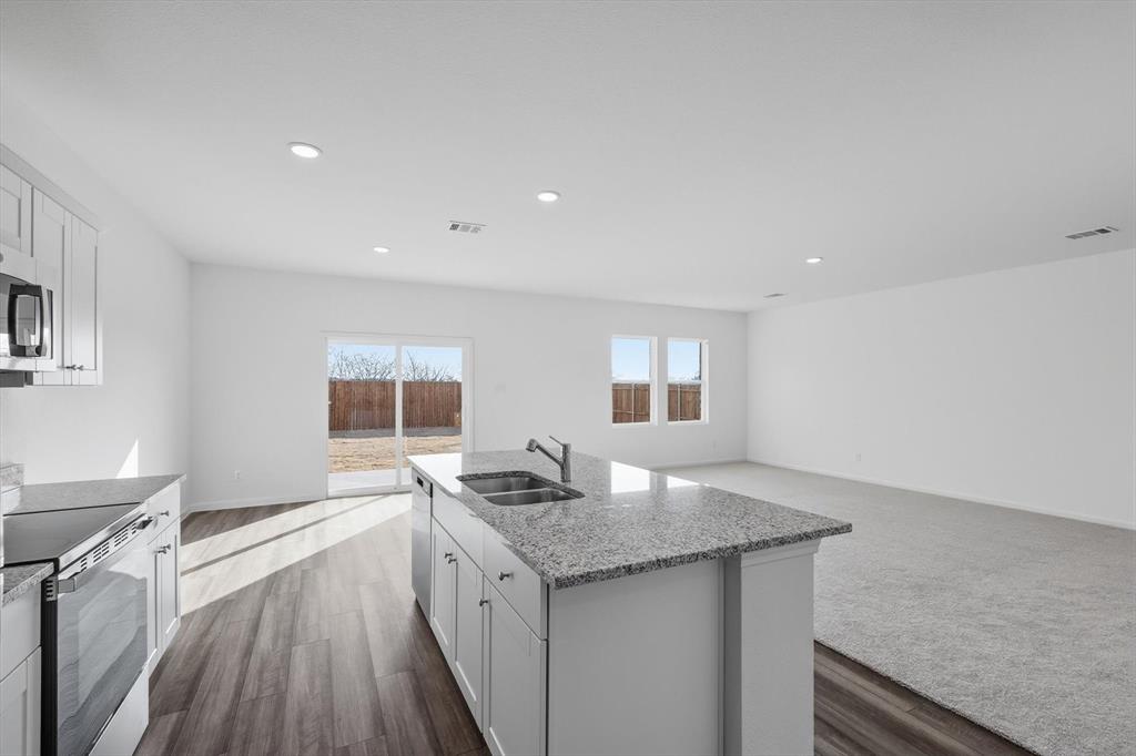 2018 Prairie Lane Melissa, TX 75454 - Photo 38 of 40 a open kitchen with granite countertop a sink stove and refrigerator