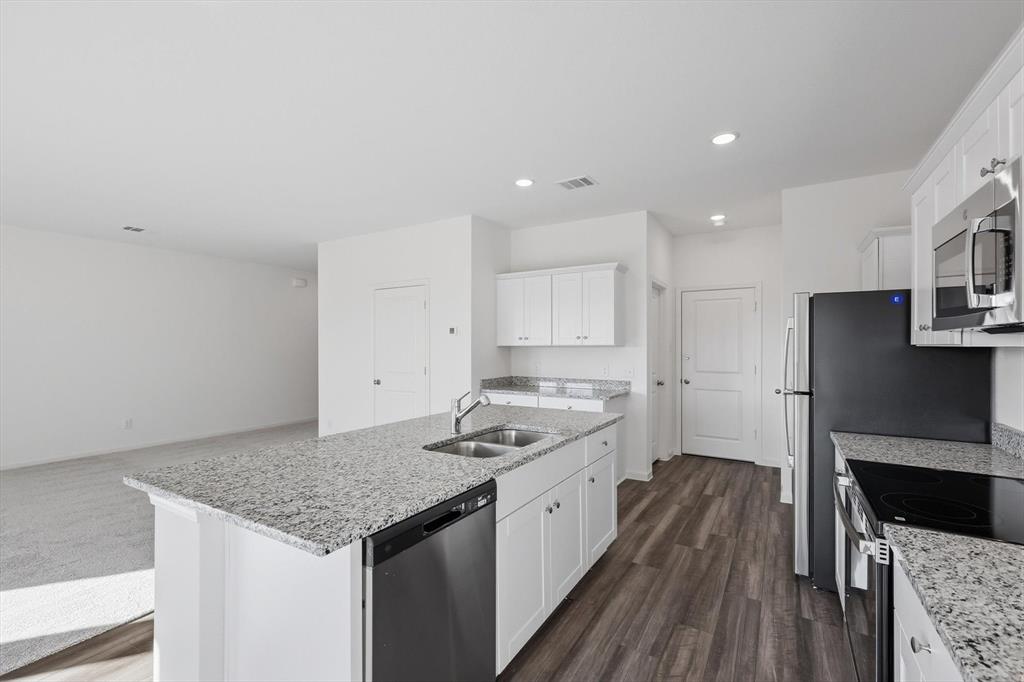 2018 Prairie Lane Melissa, TX 75454 - Photo 39 of 40 a kitchen with granite countertop a sink stove and refrigerator