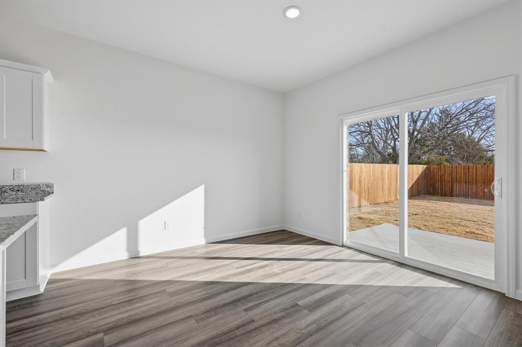 2018 Prairie Lane Melissa, TX 75454 - Photo 14 of 40 a view of an empty room with wooden floor and a window