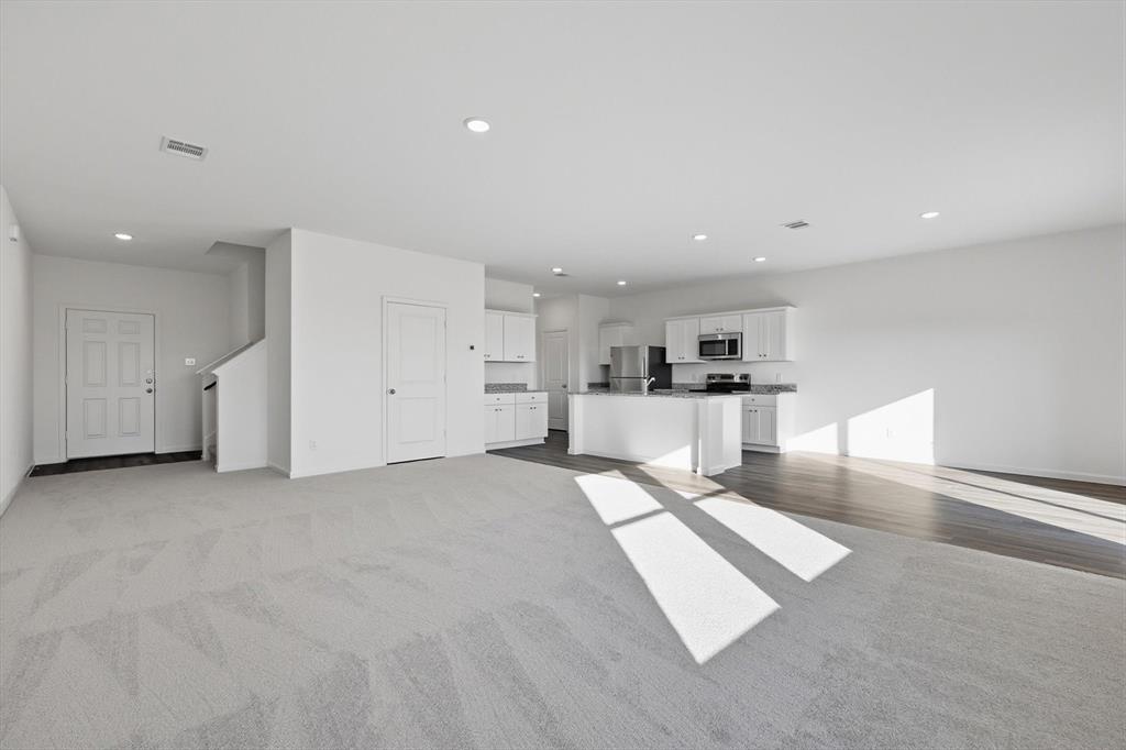 2018 Prairie Lane Melissa, TX 75454 - Photo 8 of 40 a large white kitchen with kitchen island a sink a stove and cabinets
