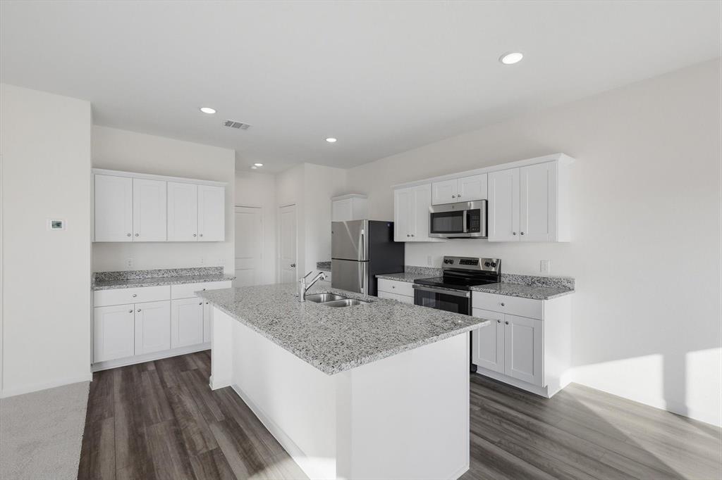 2018 Prairie Lane Melissa, TX 75454 - Photo 10 of 40 a kitchen with stainless steel appliances granite countertop a sink stove microwave and refrigerator