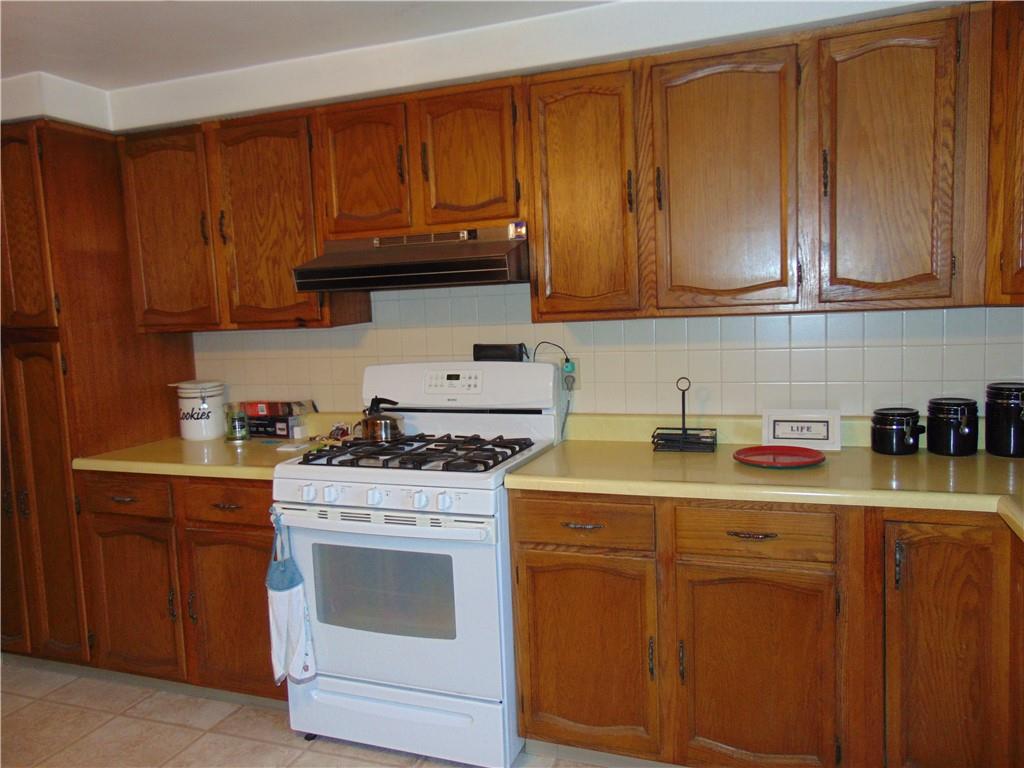 5569 Aiken Road McKees Rocks, PA 15136 - Photo 9 of 24 a kitchen with stainless steel appliances granite countertop a stove a sink dishwasher and cabinets with wooden floor