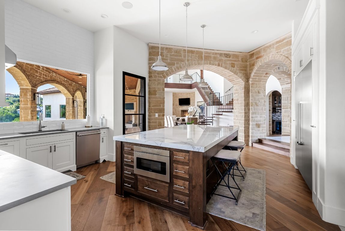 12109 Musket Rim Street Austin, TX 78738 - Photo 15 of 38 a kitchen with stainless steel appliances granite countertop a lot of counter space and wooden floors