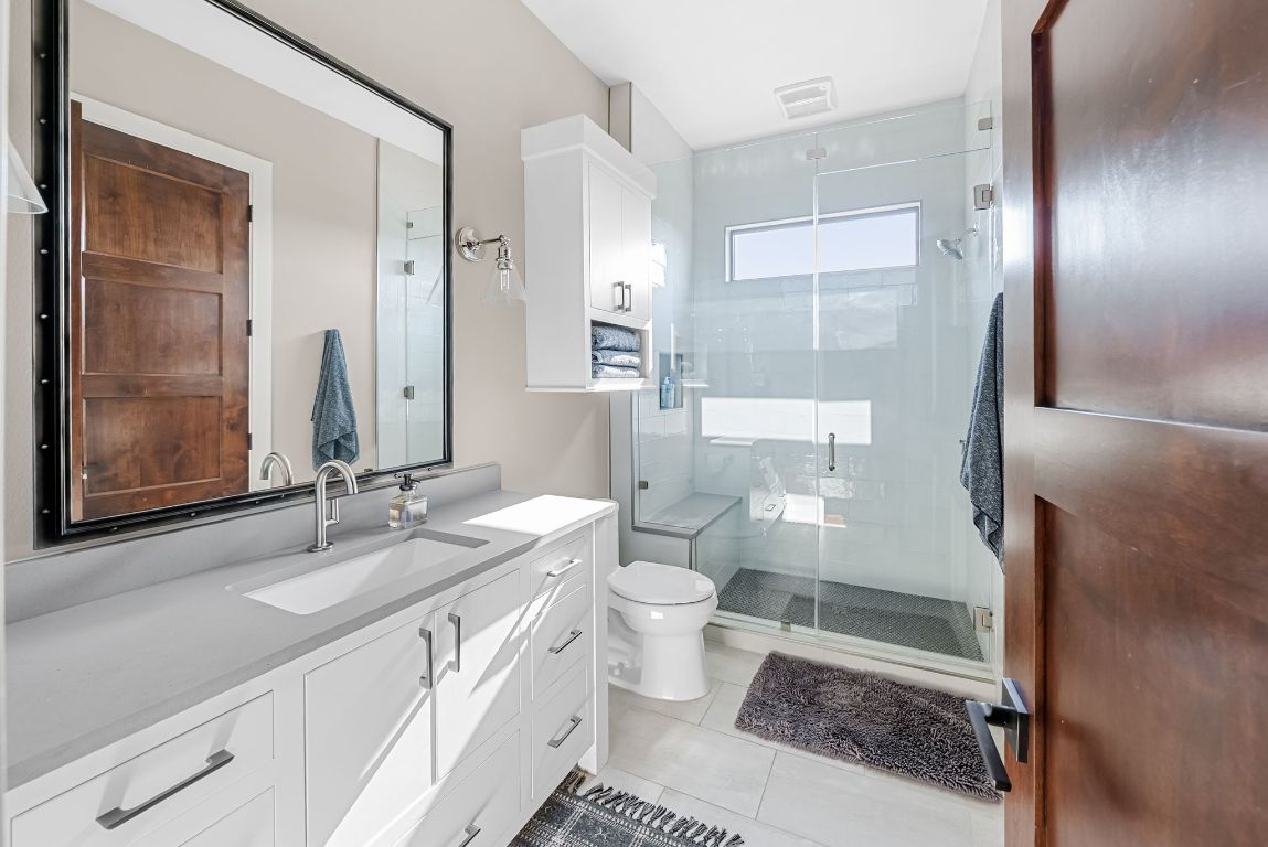 12109 Musket Rim Street Austin, TX 78738 - Photo 28 of 38 a bathroom with a double vanity sink toilet and shower