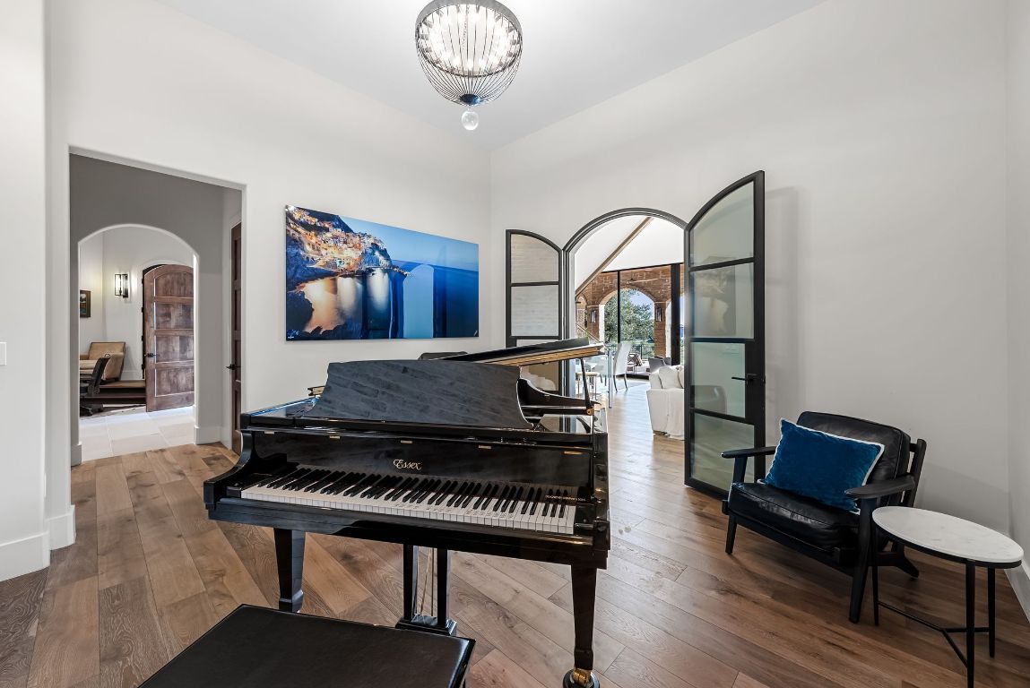12109 Musket Rim Street Austin, TX 78738 - Photo 33 of 38 a living room with furniture a rug and a chandelier