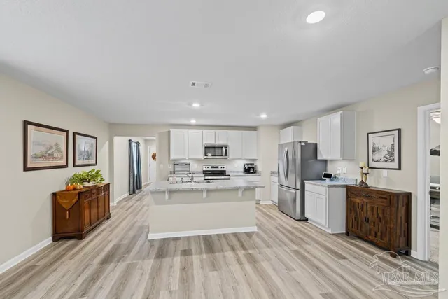 a kitchen with stainless steel appliances a stove top oven a sink dishwasher and a refrigerator