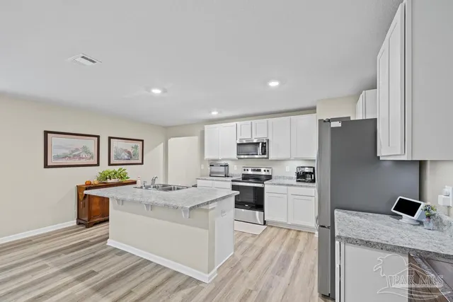a kitchen with stainless steel appliances granite countertop refrigerator sink and stove