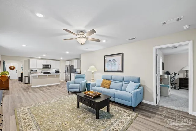 a living room with furniture and view of kitchen