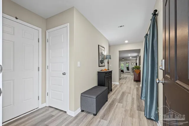 a view of a hallway with wooden floor windows and a livingroom