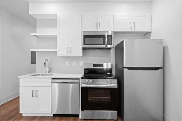 a kitchen with stainless steel appliances white cabinets and a refrigerator