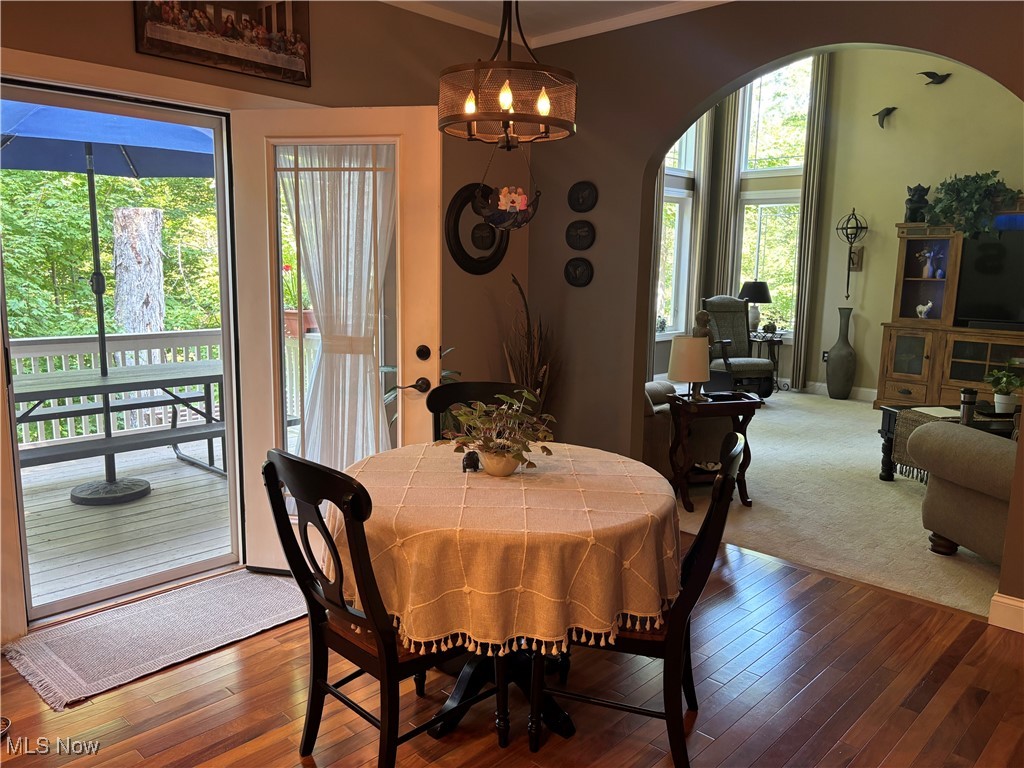 5232 Emerson Road Madison, OH 44057 - Photo 18 of 48 Dining space with arched walkways, hardwood / wood-style floors, a chandelier, and crown molding