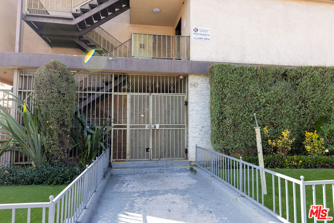 947 South Westmoreland Avenue, Unit 310 Los Angeles, CA 90006 - Photo 15 of 17 a view of balcony with small garden and wooden fence