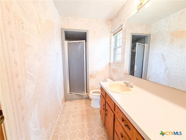 a bathroom with a sink a toilet and a window