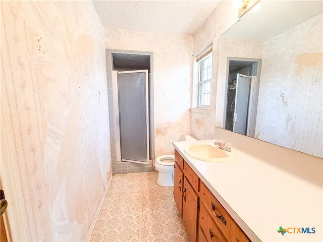 a bathroom with a sink a toilet and a window