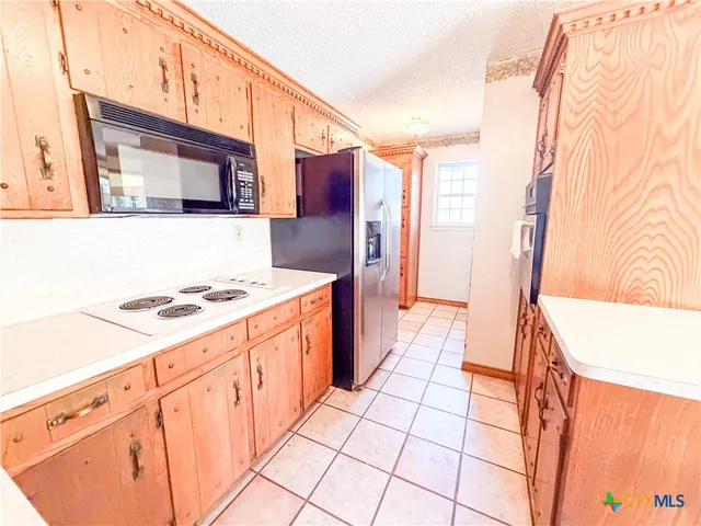 a kitchen with stainless steel appliances a stove a sink and a refrigerator