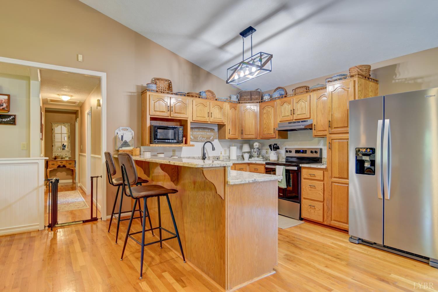 151 Anderson Place Rustburg, VA 24588 - Photo 7 of 57 a kitchen with stainless steel appliances kitchen island granite countertop a refrigerator a stove top oven a sink and dishwasher a dining table with wooden floor