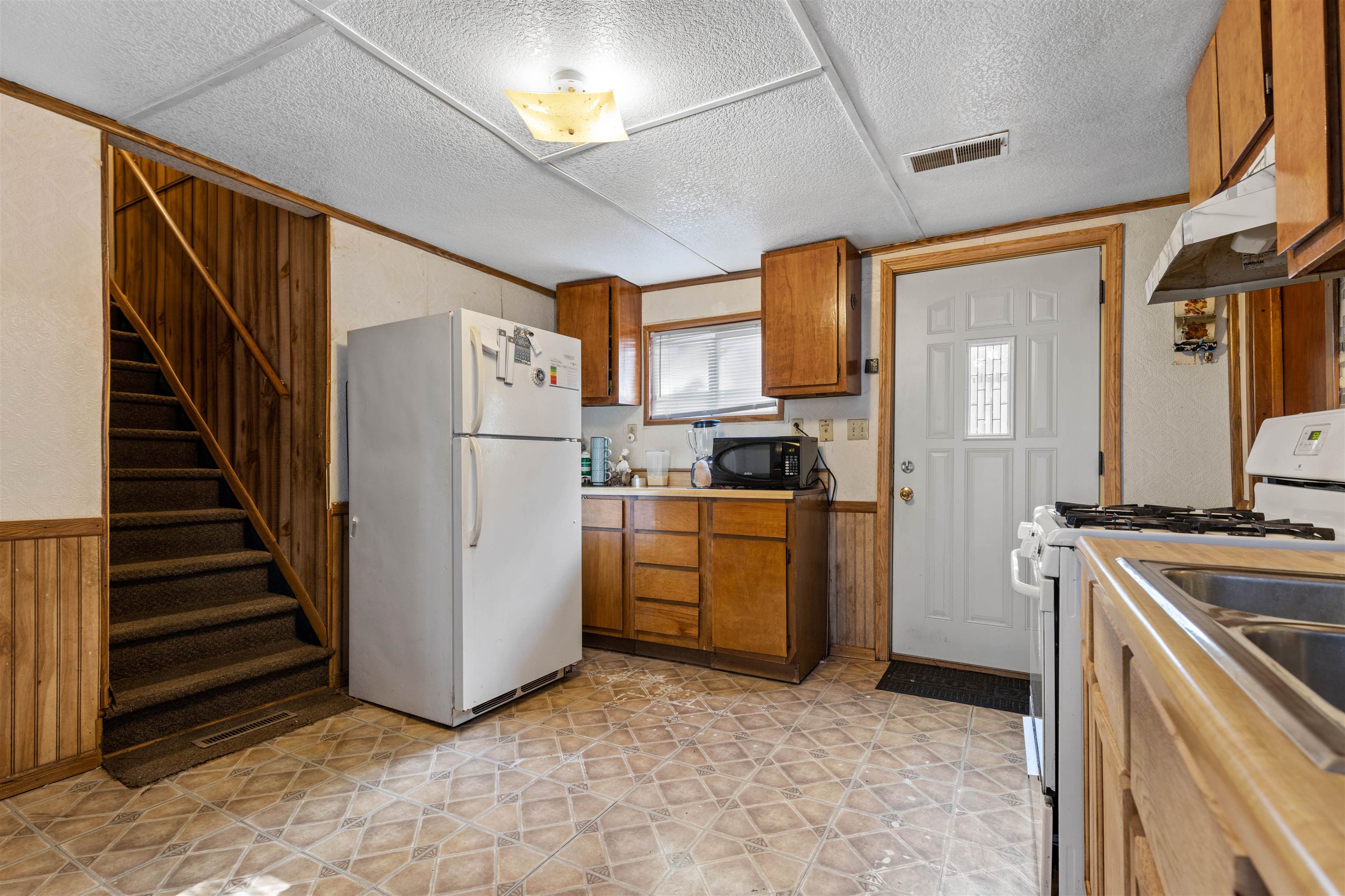 120 5th Street Capron, IL 61012 - Photo 4 of 13 a kitchen with cabinets and white appliances