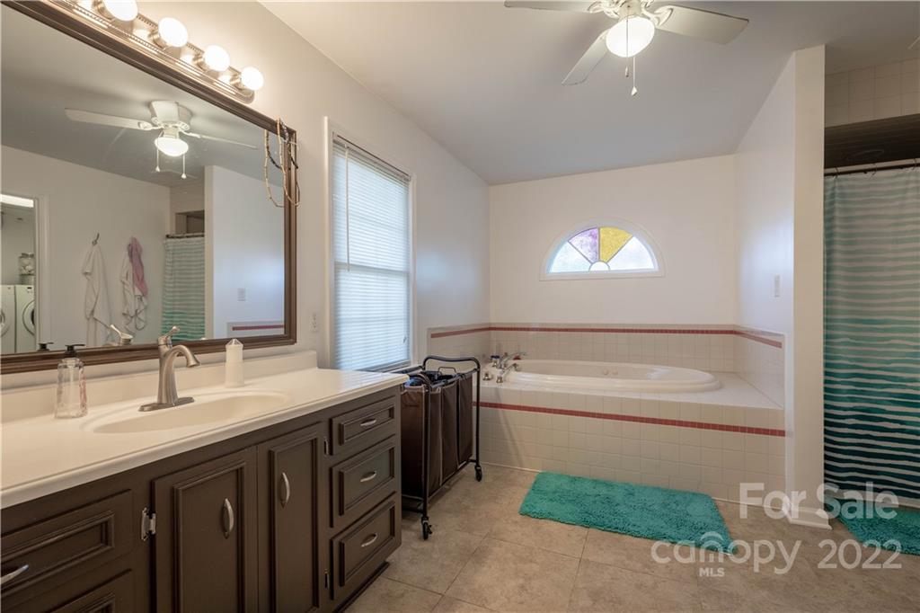 7680 Rhodhiss Road Connelly Springs, NC 28612 - Photo 9 of 25 a bathroom with a sink a large mirror and a bathtub