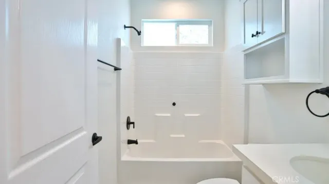 a bathroom with a granite countertop bathtub shower and sink