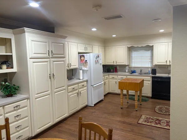 a kitchen with refrigerator cabinets and wooden floor