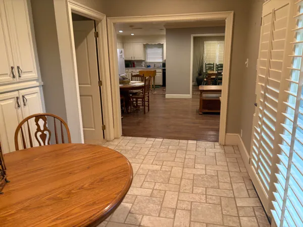 a kitchen with stainless steel appliances kitchen island granite countertop a sink a stove a table and chairs