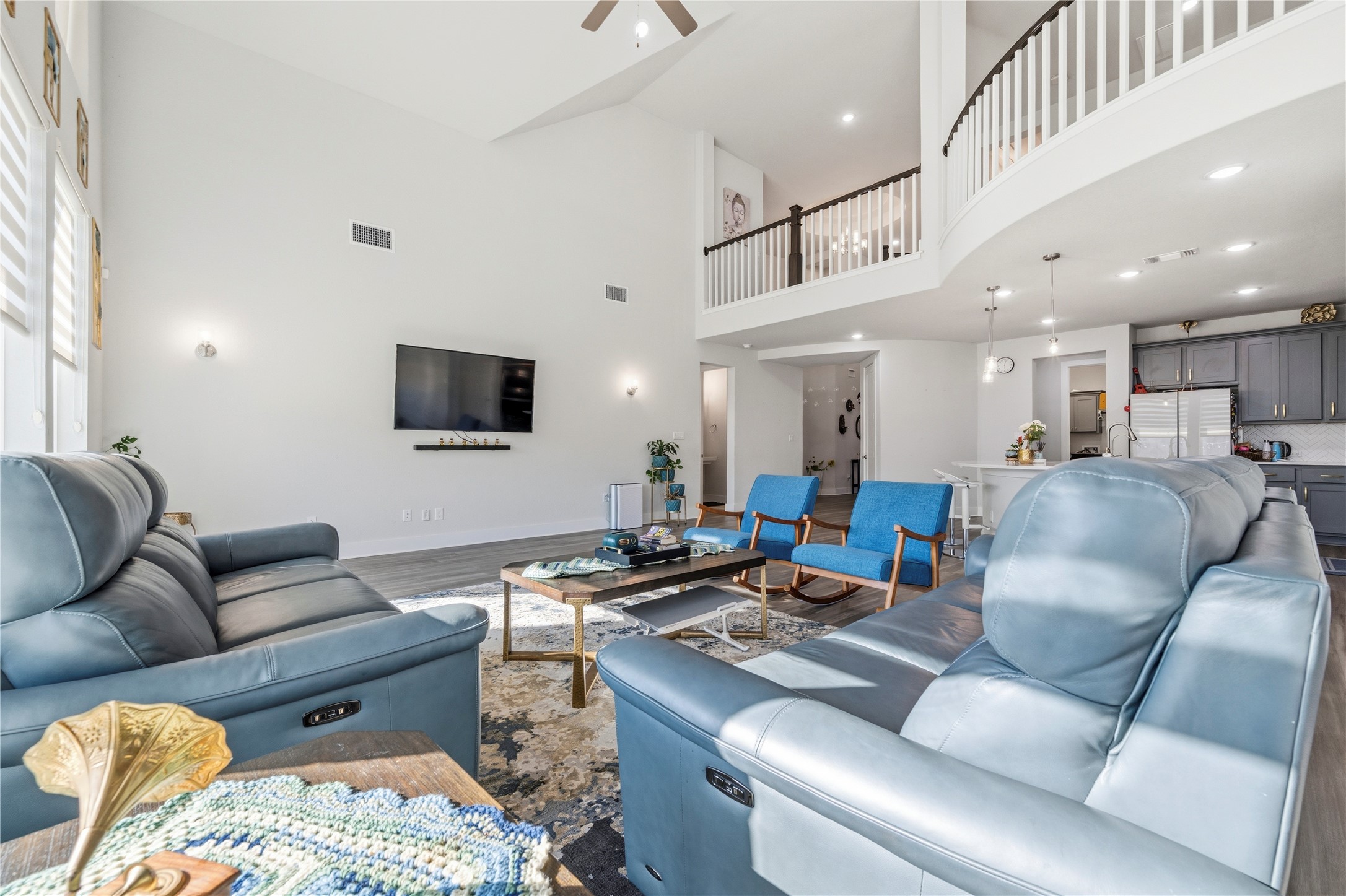 105 Autumn Oak Way Georgetown, TX 78628 - Photo 11 of 40 Expansive open-concept living area featuring vaulted ceilings, wood-finish flooring, and a second-story balcony with white balusters