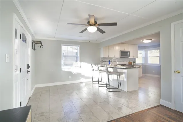 a view of a dining area with chandelier fan and wooden floor