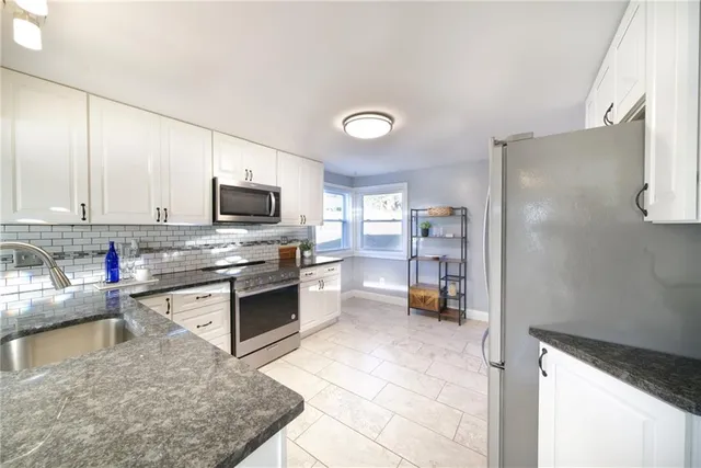 a kitchen with stainless steel appliances granite countertop a refrigerator stove top oven a sink and dishwasher