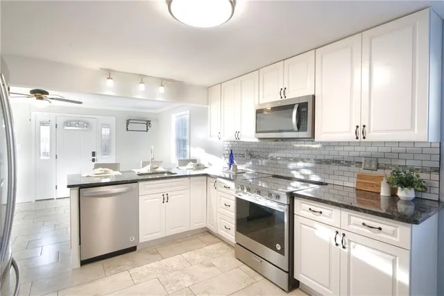 a kitchen with granite countertop white cabinets and white appliances