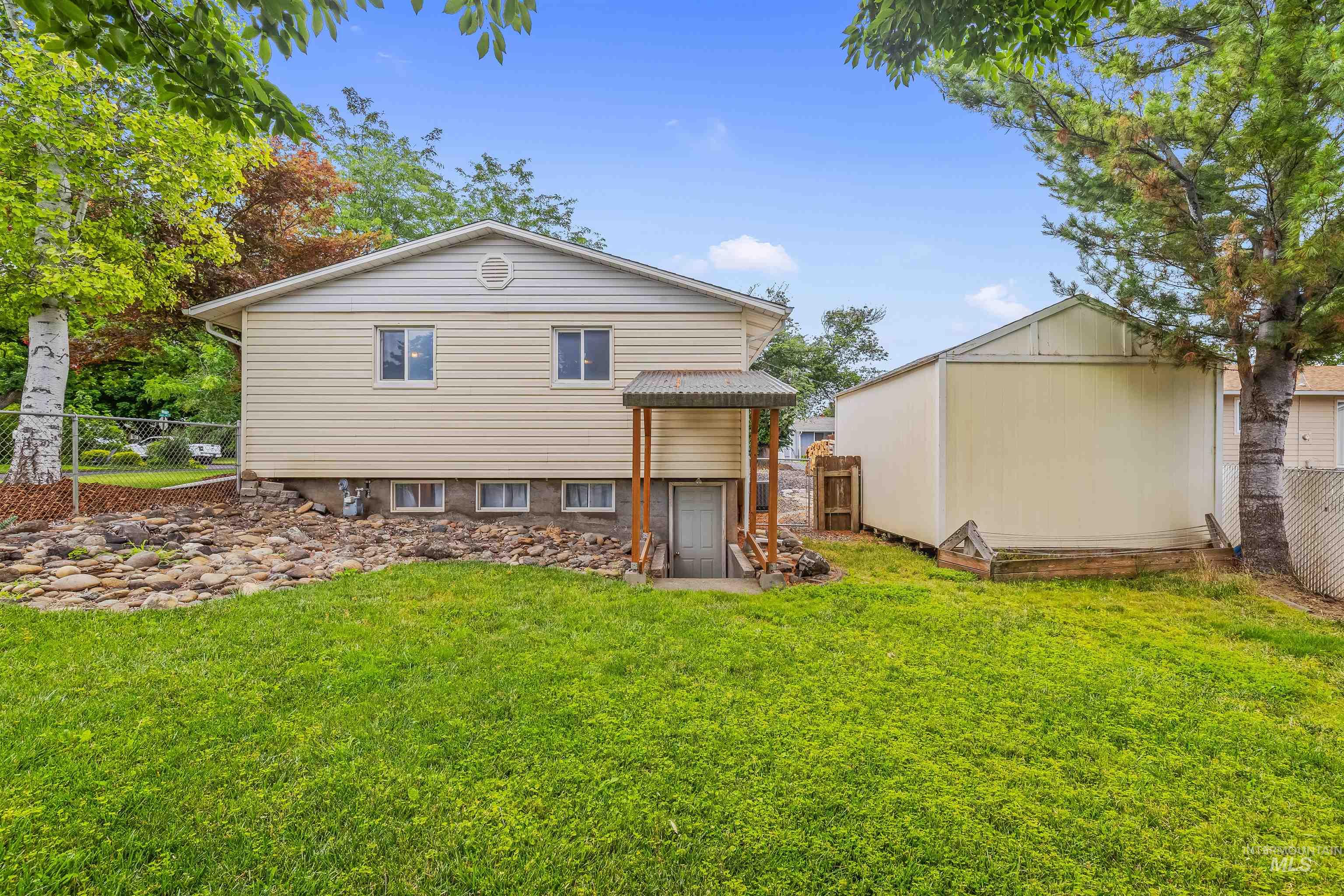 3620 18th Street Lewiston, ID 83501 - Photo 28 of 32 Spacious backyard featuring a substantial storage shed, a manicured lawn, a rock garden, and mature trees
