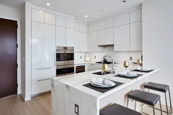 a kitchen with a sink a stove and chairs