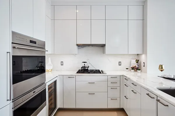 a kitchen with white cabinets and appliances