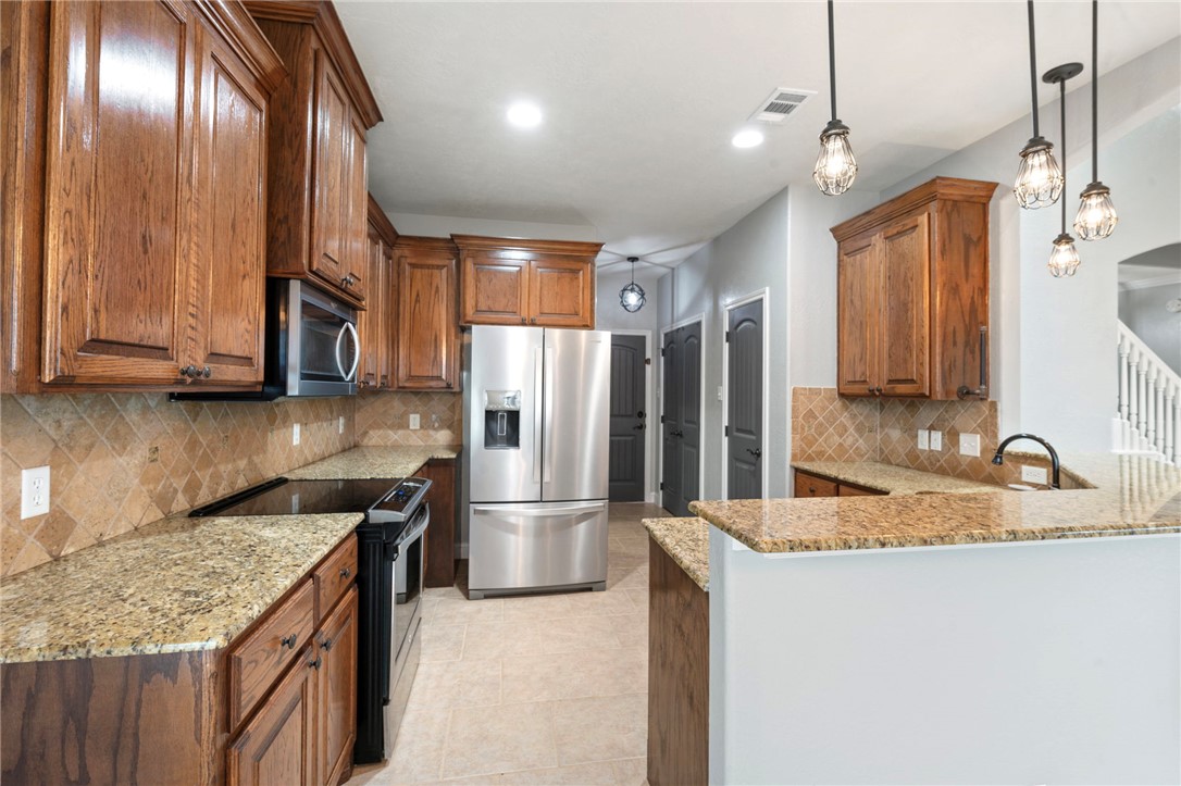 3304 Keefer Loop College Station, TX 77845 - Photo 5 of 21 a kitchen with granite countertop stainless steel appliances a refrigerator and a sink